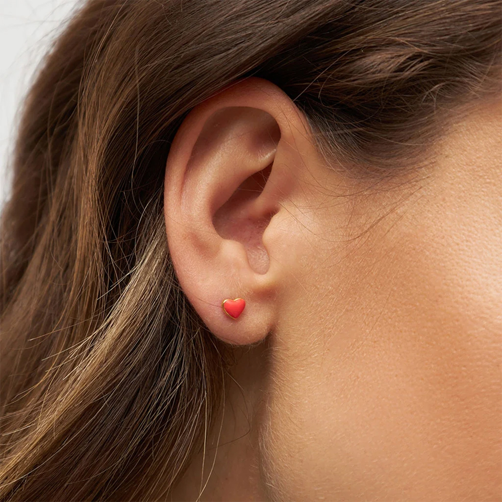Vergoldeter Ohrring in Form eines Herzen in rot im Ohr von lulu copenhagen